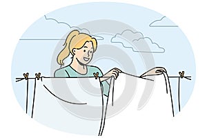 Smiling woman hanging clothes to dry