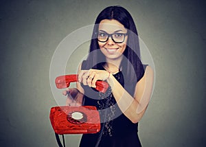 Smiling woman hanging up an old phone