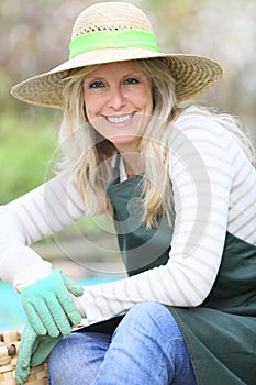 Smiling woman with hat working in garden