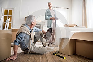 Smiling woman having discussion with husband at new home