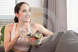 Smiling woman having healthy breakfast at home after yoga workout with happiness