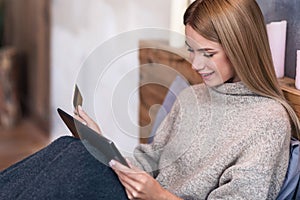 Smiling woman having online shopping in bed