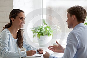 Smiling woman having pleasant conversation with male colleague