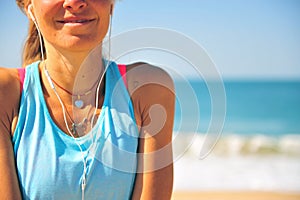 Smiling woman with headphones on beach