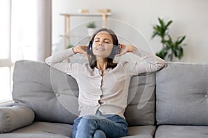 Smiling woman in headphones enjoying music with closed eyes