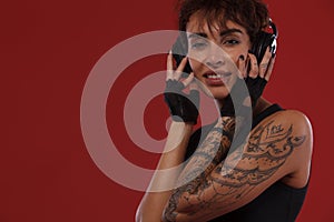 Smiling woman with headphones and tattoos. Cover for music album.