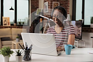 Smiling woman in headphones watching movie on streaming service