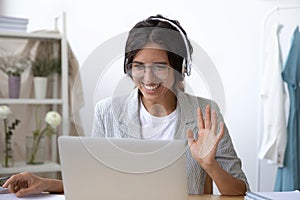 Smiling woman in headset talk on video call on laptop