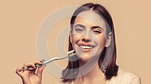 Smiling woman with healthy beautiful teeth holding a toothbrush. Dental health background. Close up of perfect and