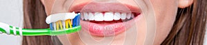 Smiling woman with healthy beautiful teeth holding a toothbrush. Dental health background. Close up of perfect and