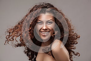 Smiling woman with healthy brown curly hair