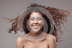 Smiling woman with healthy brown curly hair