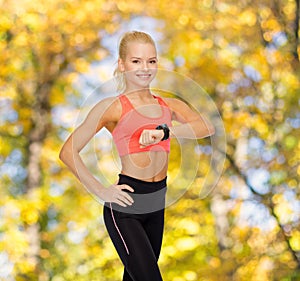 Smiling woman with heart rate monitor on hand