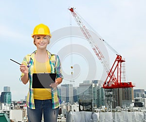 Smiling woman in helmet with clipboard