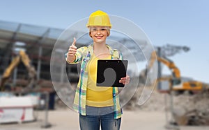 Smiling woman in helmet with clipboard