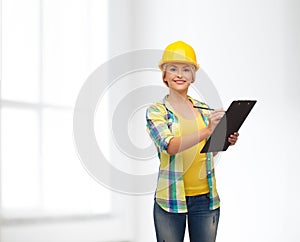 Smiling woman in helmet with clipboard