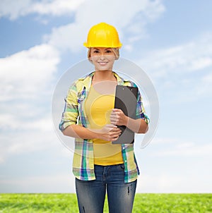 Smiling woman in helmet with clipboard