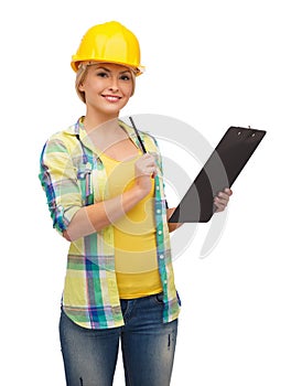 Smiling woman in helmet with clipboard