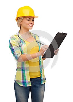 Smiling woman in helmet with clipboard