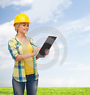 Smiling woman in helmet with clipboard