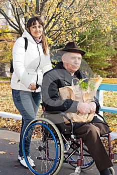 Smiling woman helping her disabled father