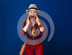 Smiling woman hiker shouting through megaphone shaped hands