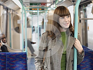 Smiling Woman Holding Bar In Commuter Train