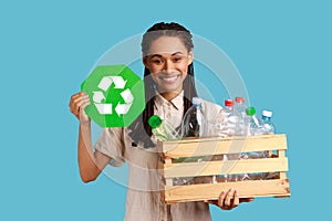 Smiling woman holding box with plastic bottles, Recycling, waste sorting and sustainability.