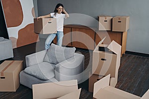 Smiling woman holding cardboard box moving to new home. Mortgage advertising, relocation concept