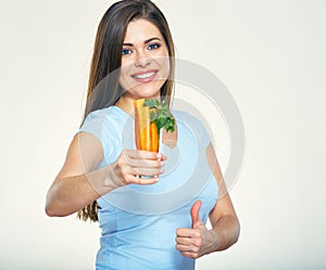 Smiling woman holding carrot showing thumb up