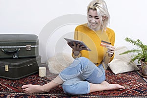 Smiling Woman Holding Credit Card and Digital Tablet at Home