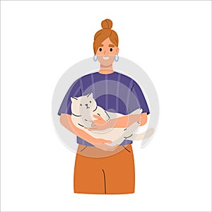 Smiling woman holding cute cat in hands. Happy owner with adorable sweet kitty in arms