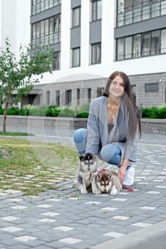 Smiling woman holding cute husky puppy