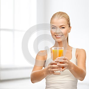 Smiling woman holding glass of orange juice