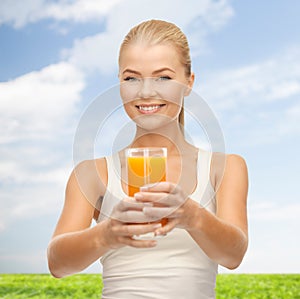 Smiling woman holding glass of orange juice