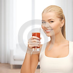 Smiling woman holding glass of tomato juice