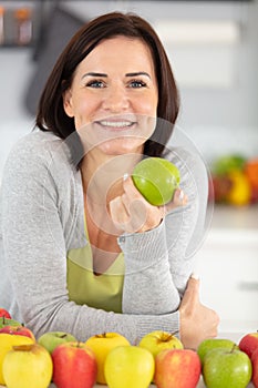 smiling woman holding green apple