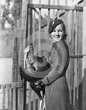 Smiling woman holding live turkey