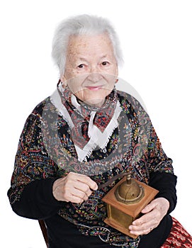 Smiling woman holding old coffee grinder in studio