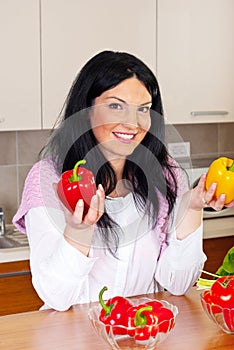 Smiling woman holding red and yellow peppers