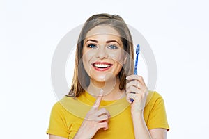 Smiling woman holding toothy brush. studio portrait.