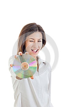 Smiling woman holding up compact disc or cd and looking at came