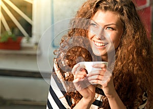 Smiling woman holding a warm beverage