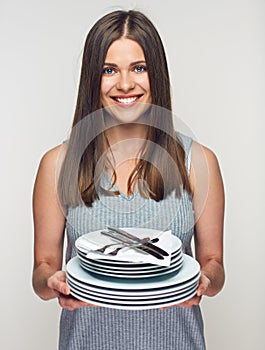 Smiling woman holding white crockery set