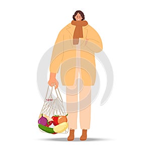 Smiling woman holding Zero waste string bag. Girl wearing warm comfortable fashionable casual clothes goes with
