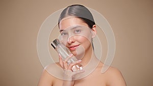 Smiling woman holds bottle with cosmetic tonic