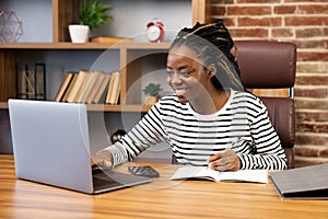 Smiling Woman at Home Office Using Laptop for Video Calls and Blogging