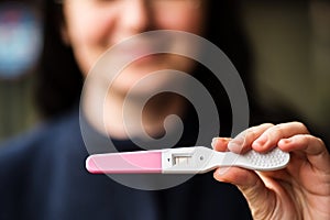 Smiling woman with home pregnancy test