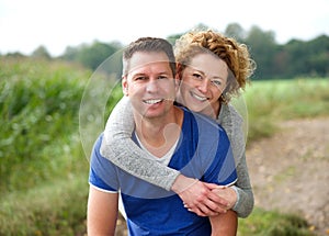 Smiling woman hugging her boyfriend outdoors