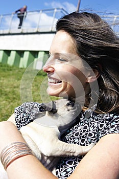 Smiling woman hugging pug puppy